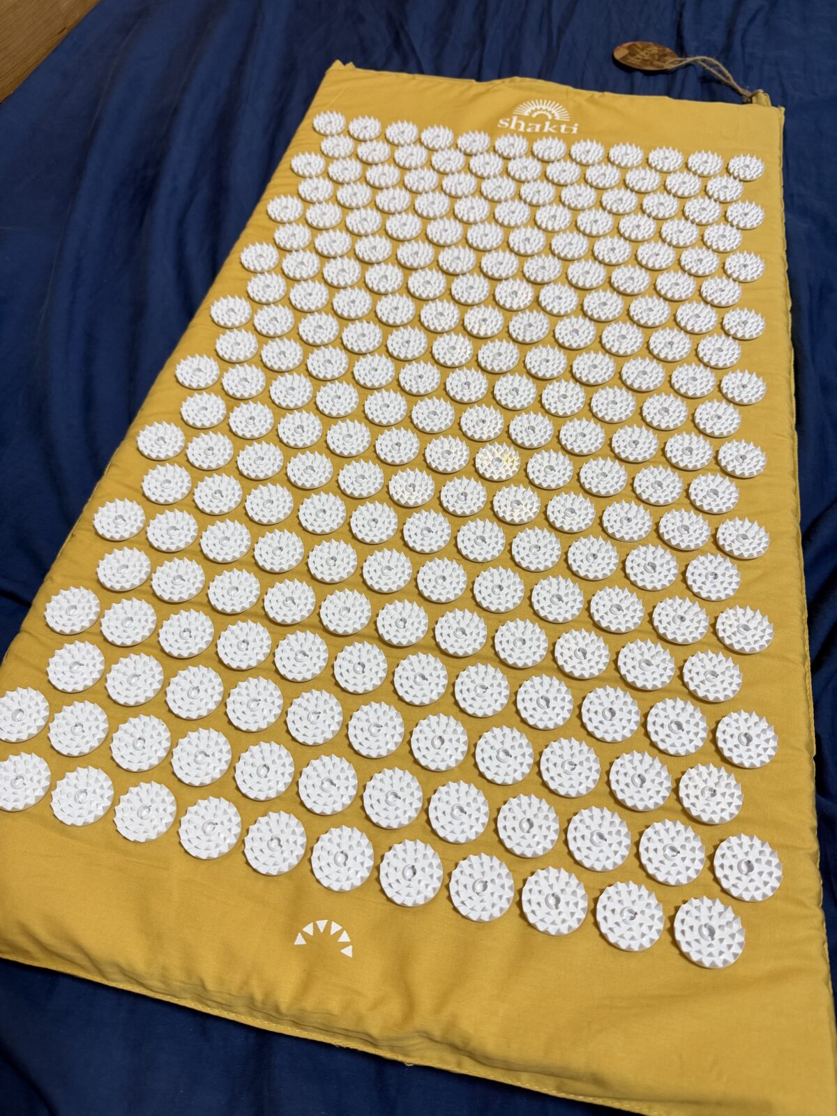ベッドに広げた黄色いシャクティマット